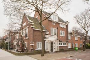 a large brick house with a tree in front of it at Casa Julia in Delft