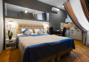 a bedroom with a large bed and a kitchen at ANTARES Apart hotel in Lviv