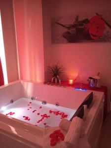 ブリンディジにあるHotel Masseria Marzialeのバスルーム(赤い花でいっぱいのバスタブ付)