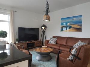 a living room with a couch and a flat screen tv at Villa Louisa - Liegestuhl 45 in Ostseebad Sellin