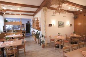 a restaurant with tables and chairs in a room at Landhaus Bergidyll in Bärenstein