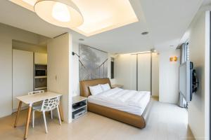 a bedroom with a bed and a table and a desk at 謙匯國際酒店式公寓 CH Service Apartment in Taipei +44 photos