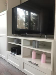 a television on a white entertainment center with pink speakers at Wilschenbruch in Lüneburg