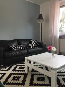 a living room with a black couch and a white coffee table at Wilschenbruch in Lüneburg