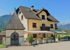 a large white building with a black roof at Guest House Vila Moj Mir in Rateče