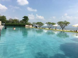 uma grande piscina com pessoas na água em HuiZhou HuaYangNian Seaview Guesthouse em Huidong