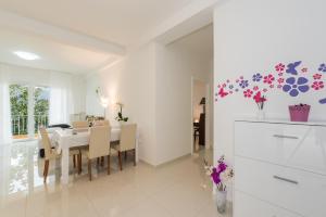 a kitchen and dining room with a table and chairs at Allegro in Rabac