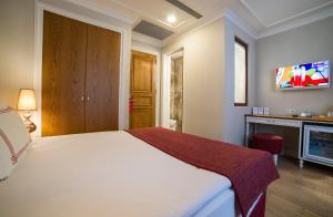 ein Schlafzimmer mit einem großen weißen Bett und einem Schreibtisch in der Unterkunft Amofta Hotel Taksim in Istanbul