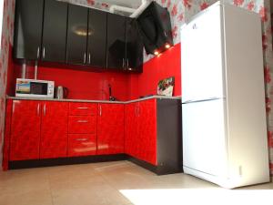 トゥーラにあるInndays on Liteinaya 22aのキッチン(赤いキャビネット、冷蔵庫付)