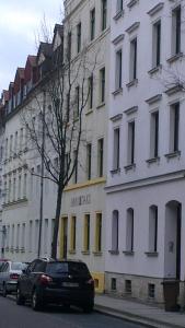 ライプツィヒにある2 Ferienwohnungen in einem Haus 2 km vom Zentrum Leipzigsの建物前に停車する黒車