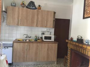 a kitchen with wooden cabinets and a microwave on a counter at Cortijo La Huerta in Pilas de Fuente Soto