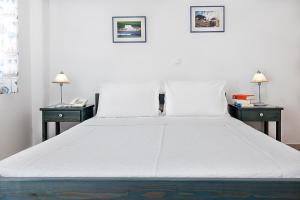 a large white bed with two nightstands and two lamps at San Antonio Summer House in Piso Livadi