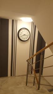 a clock on a wall next to a staircase at Willa Karo in Muszyna