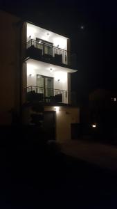 a lit up building with a balcony in the dark at Willa Karo in Muszyna