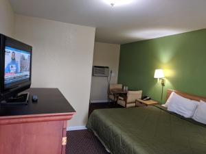 ein Hotelzimmer mit Bett und Flachbildfernseher in der Unterkunft Benton Inn in Benton