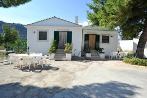 Casa blanca con mesa y sillas en Case Vacanze Uliveto, en Mattinata