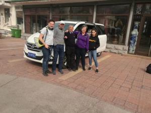 a group of people standing in front of a car at Tianjin Jixian Libo Family Farmstay in Jizhou