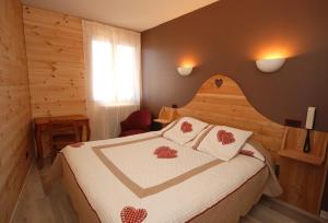 a bedroom with a bed with a heart shaped headboard at Auberge du Rochasson in Risoul