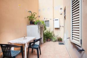 einen Tisch und Stühle auf einer Terrasse mit Pflanzen in der Unterkunft Davi in Cagliari