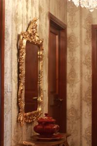 a mirror on a wall with a red vase on a table at Vintage room in Florence