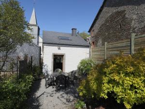 ManhayにあるBeautiful Cottage in Malempre with Fenced Gardenのパティオ(テーブル、椅子付)、
