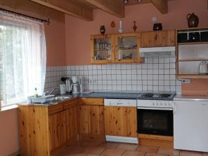 ベルガーエンデ・レートヴィッシュにあるRestful Holiday Home in Rethwisch with Sauna and Whirlpoolのキッチン(木製キャビネット、白い電化製品付)