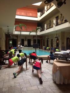 a group of people doing yoga in front of a swimming pool at Hotel Gran Mediterraneo in San Pedro Sula