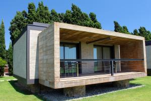 a small house with a deck on the grass at URH - Hotel Molí del Mig in Torroella de Montgrí