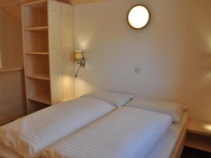ザンクト・ローレンツェン・オプ・ムーラウにあるVoguish Apartment in Sankt Georgen ob Murau near Ski Areaのベッド1台、棚、照明が備わる客室です。