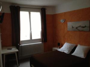 a bedroom with a bed and a large window at La Locomotive in Issoudun