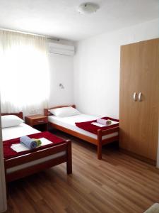 a hotel room with two beds and a window at Pansion Crnjac in Međugorje