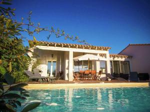 a villa with a swimming pool in front of a house at Beautiful Holiday Home with Swimming Pool in Narbonne in Narbonne