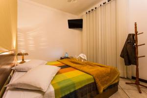 Uma cama ou camas num quarto em Pousada Águas de Caxambu