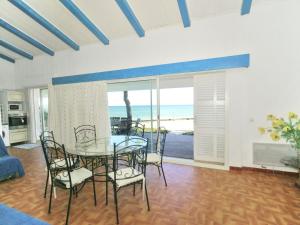 una sala da pranzo con tavolo, sedie e vista sull'oceano di Attractive Villa in Moriani Plage at Sea a San-Nicolao