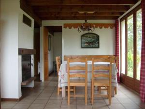 una sala da pranzo con tavolo e sedie di Cozy chalet with dishwasher, in the High Vosges a Le Ménil