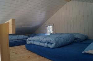a room with two blue beds in a attic at Holme Å Camping & Cottages in Hovborg