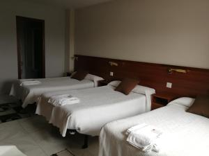 a hotel room with two beds and two tables at Hostal Cerecedo in León