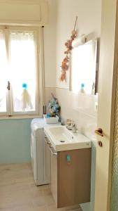 a bathroom with a sink and a washing machine at Casa Vacanza Marina, in pieno centro a pochi passi dal mare e con aria condizionata! in Diano Marina