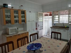 a kitchen with a table and chairs and a microwave at Casa da Cachoeira in Brotas
