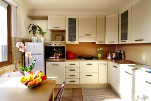 索姆馬隆巴爾多的住宿－Annabelle，厨房配有白色橱柜和一张带一碗水果的桌子