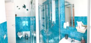 bagno piastrellato blu con lavandino e specchio di B&B Arte e Musei a Napoli