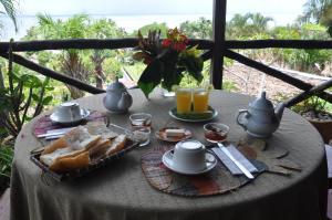 a table with a breakfast of bread and orange juice at Coucher de Soleil in Ambatoloaka