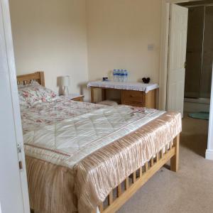 a bedroom with a large bed and a desk at Mill Farm B&B in Great Ayton