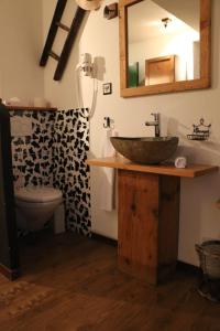 een badkamer met een wastafel, een toilet en een spiegel bij Hostellerie de Genève in Vevey