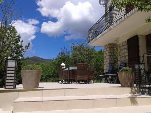 een patio met een tafel en stoelen op een huis bij Bnb Castellane Chambre d'Hotes B&B in Castellane
