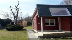 a red house with a solar panel on the roof at Gemütliches Gästehaus in Bahretal