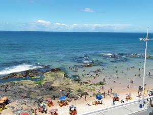 un grupo de personas en una playa cerca del océano en Pousada Mar Aberto en Salvador