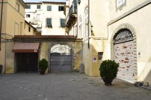 an alley with a building with a gate and some plants at Palazzo Tucci Apartments in Lucca