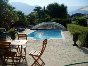 a patio with a table and chairs and a swimming pool at La Maison d'Euterpe in Sainte-Marie-dʼAlloix