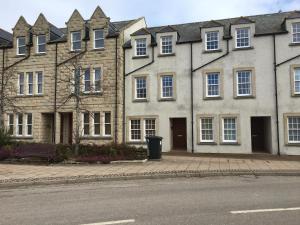 a large brick building with a bench in front of it at Castle View Place in Dornoch